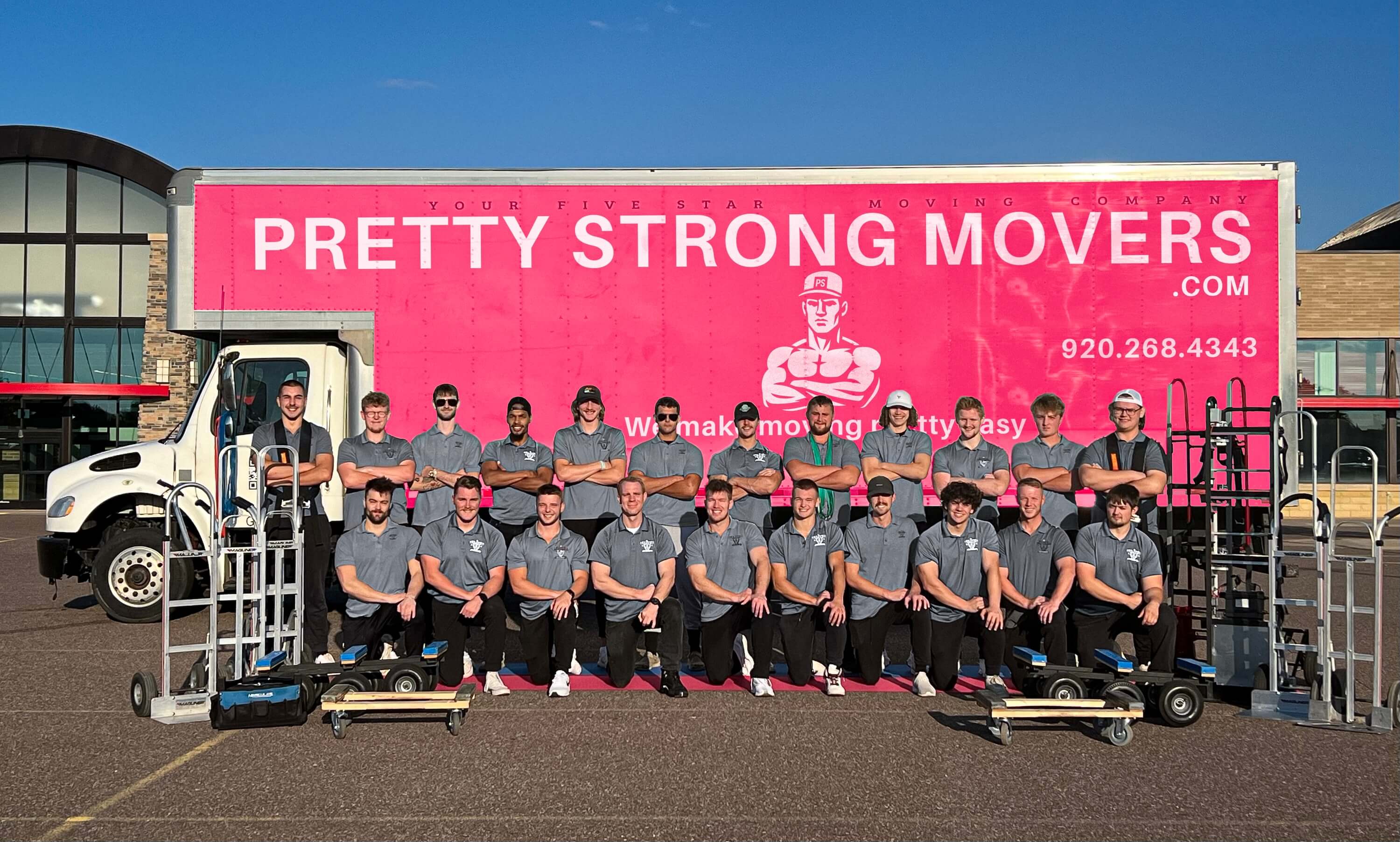 The Pretty Strong Movers crew in front of the pink Pretty Strong moving truck